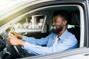 man driving a car and smiling thinking about car warranty coverage