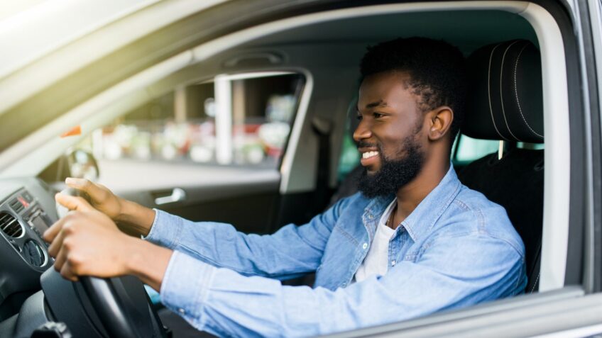 man driving a car and smiling thinking about car warranty coverage